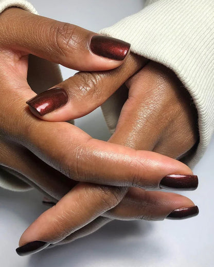 Fingers painted with Bio Sculpture Gemini Nail Polish No. 213 Rosewood Stardust on dark skin – non-toxic, rosewood pink polish with subtle sparkle for a chic, versatile look